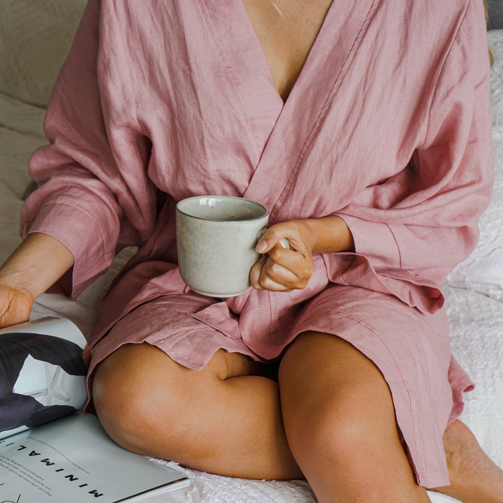 Bridesmaid wearing Harper pink linen robe drinking coffee