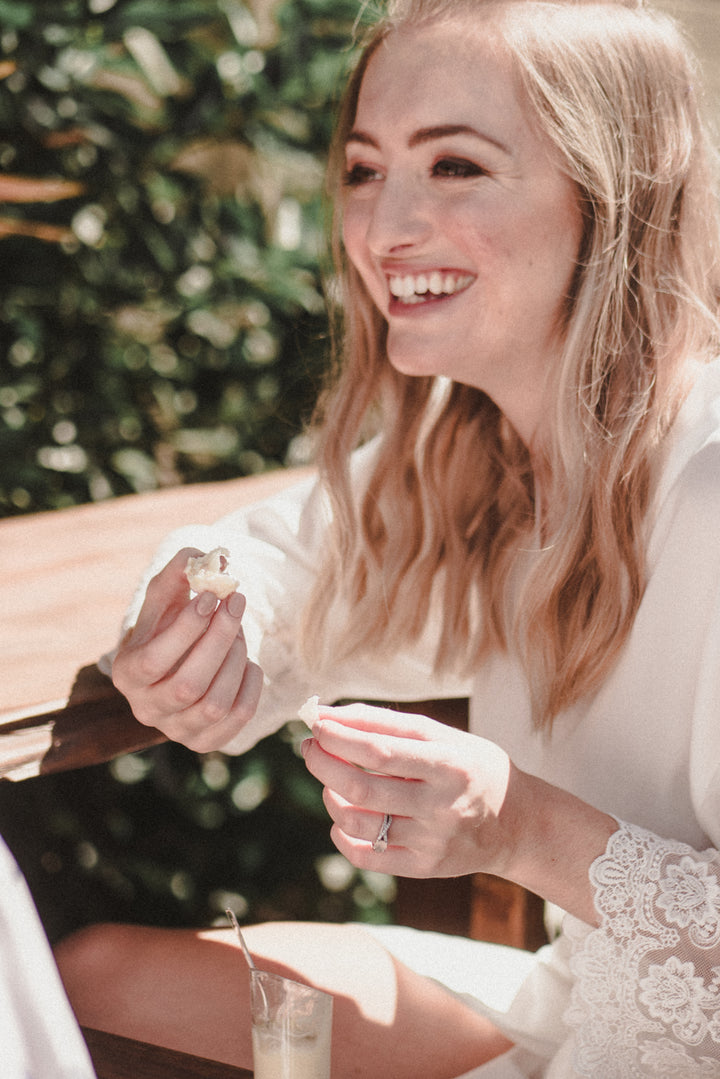 Bride wearing Lily white satin bridal robe eating
